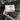 Hand holding a package of Treadmill Belt Lubricant in front of treadmills
